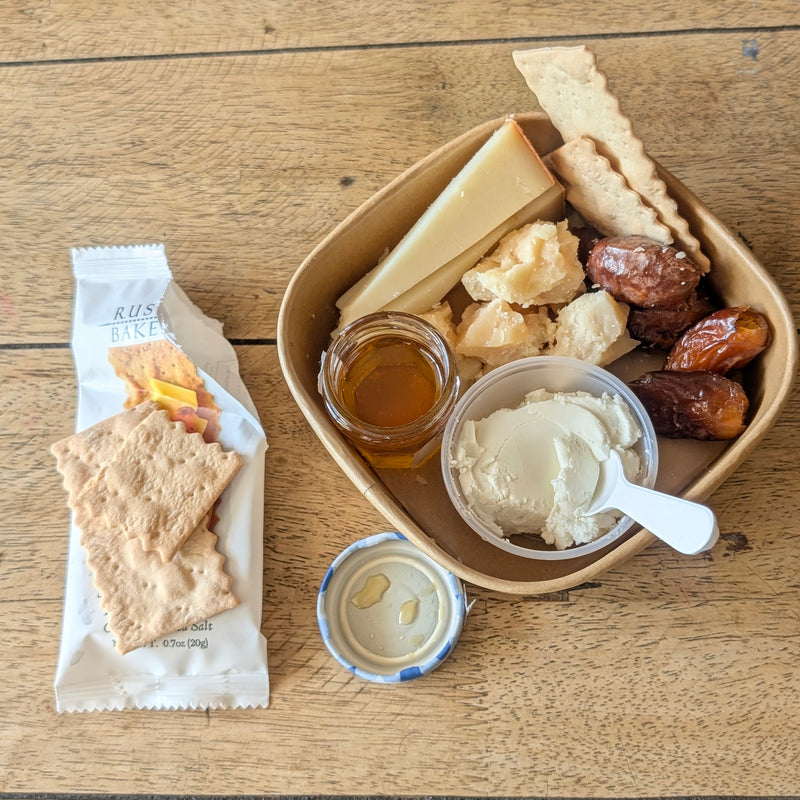 grab and go cheese plate with chevre, dates, alpine style cheese, crackers, and honey. 